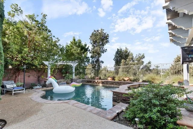 a lawn chairs and fire pit with large trees