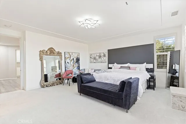 a bedroom with a bed couch and a large mirror