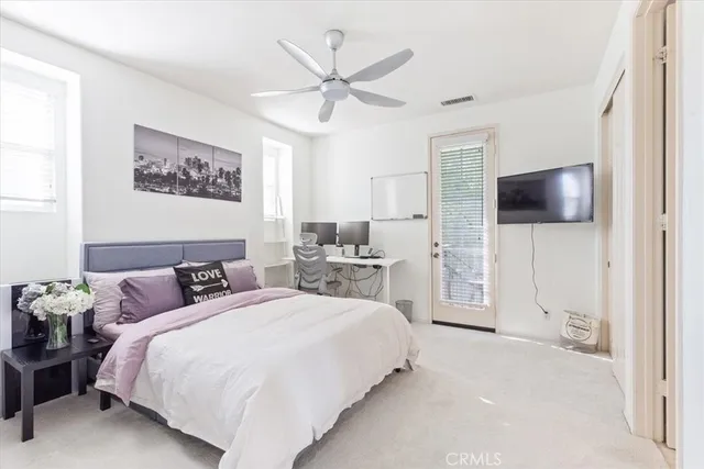 a spacious bedroom with a bed and a flat screen tv