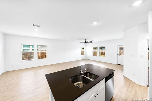 an empty room with wooden floor and black cabinet