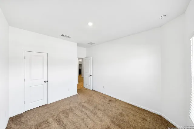 an empty room with a window and a ceiling fan