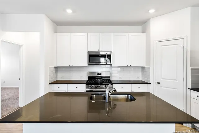 a kitchen with a sink a stove and cabinets