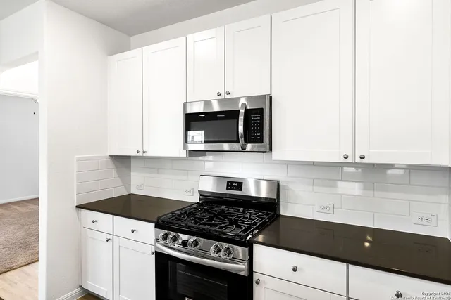 a kitchen with stainless steel appliances white cabinets and a stove