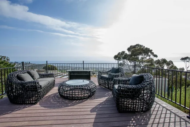 a view of roof deck with couches potted plants and ocean view