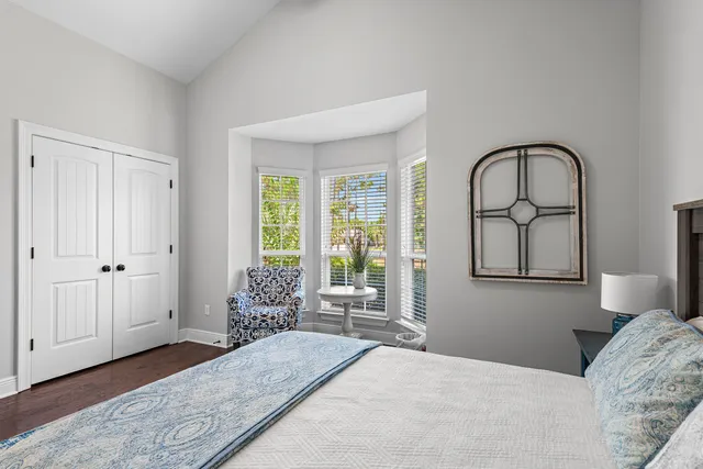 a bedroom with a bed and a large window