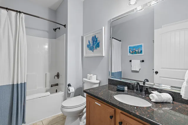 a bathroom with a granite countertop sink toilet and a mirror