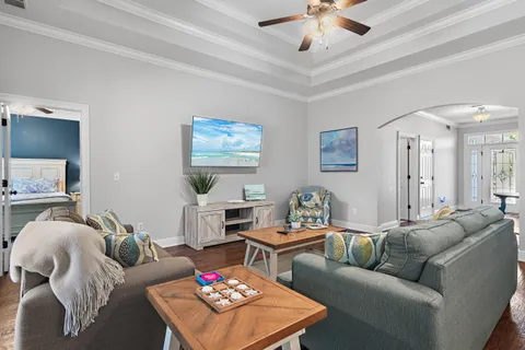 a living room with furniture a rug and a ceiling fan