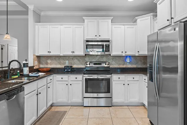 a kitchen with cabinets stainless steel appliances and a sink