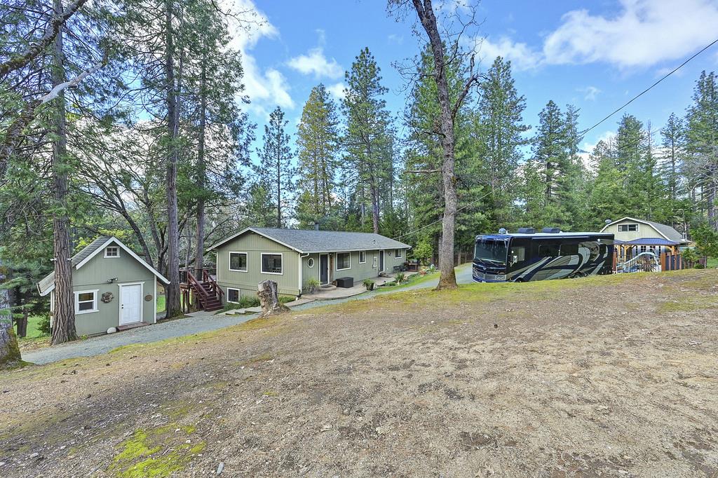 view of front of property with an outdoor structure and view of scattered trees