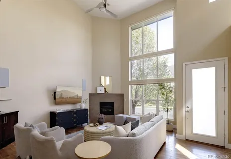 a living room with furniture a fireplace and a large window