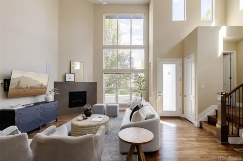 a living room with furniture a fireplace and a floor to ceiling window