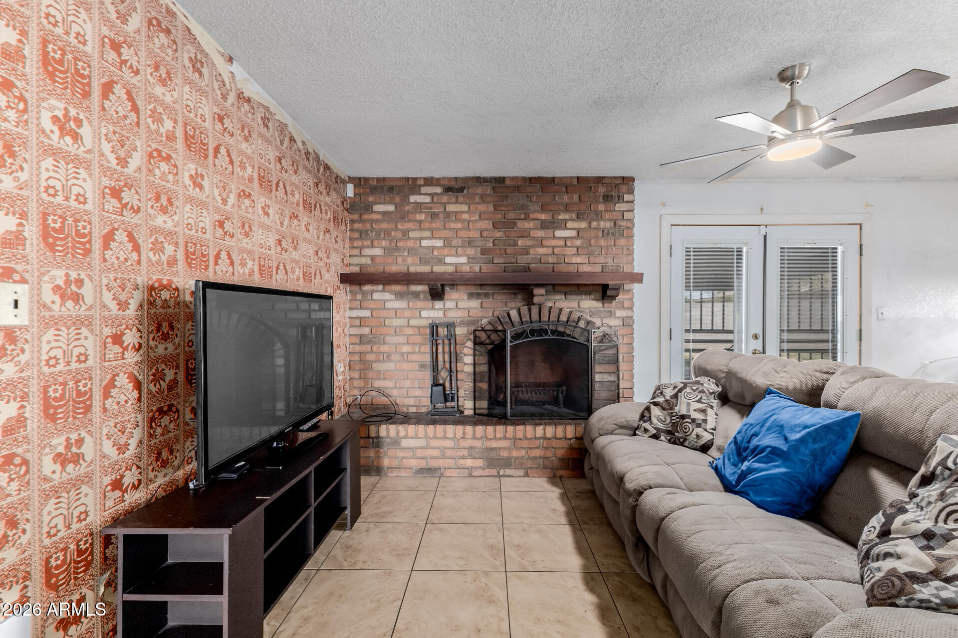 7708 West Flower Street Phoenix, AZ 85033 - Photo 14 of 35 a living room with furniture a fireplace and a flat screen tv