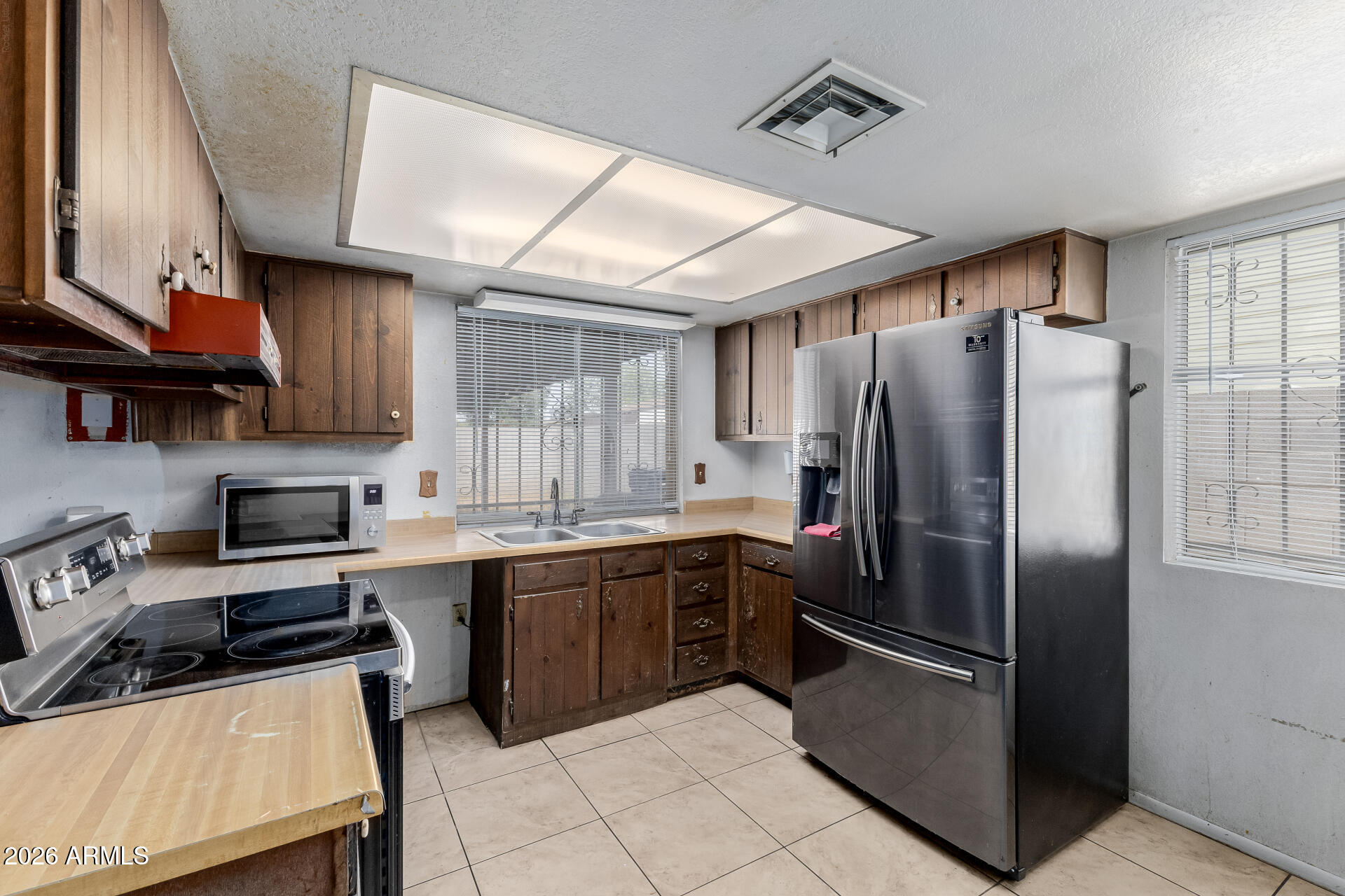 7708 West Flower Street Phoenix, AZ 85033 - Photo 17 of 35 a kitchen with stainless steel appliances granite countertop a refrigerator a sink dishwasher a stove and a refrigerator with wooden cabinets