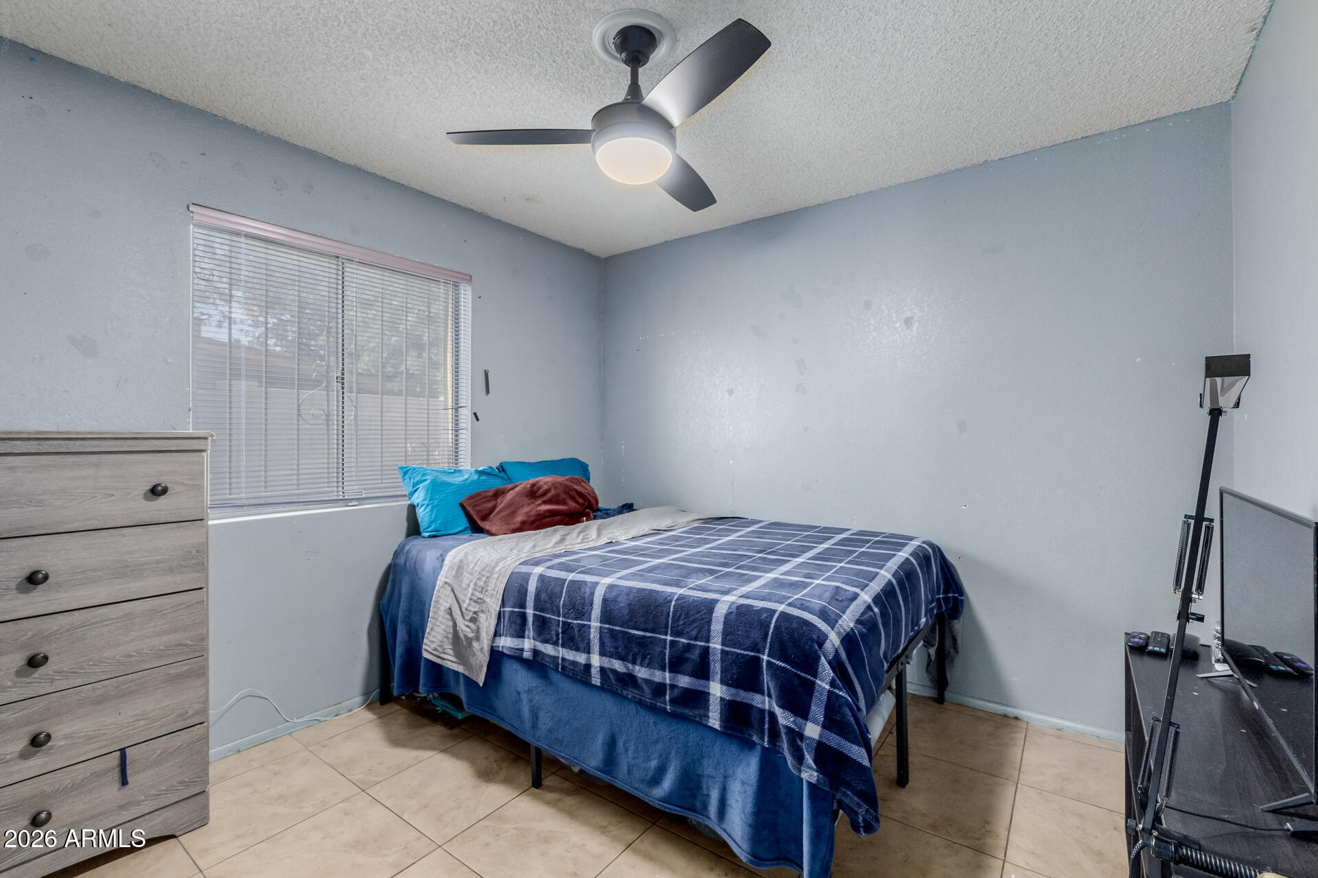 7708 West Flower Street Phoenix, AZ 85033 - Photo 24 of 35 a bedroom with a bed and ceiling fan