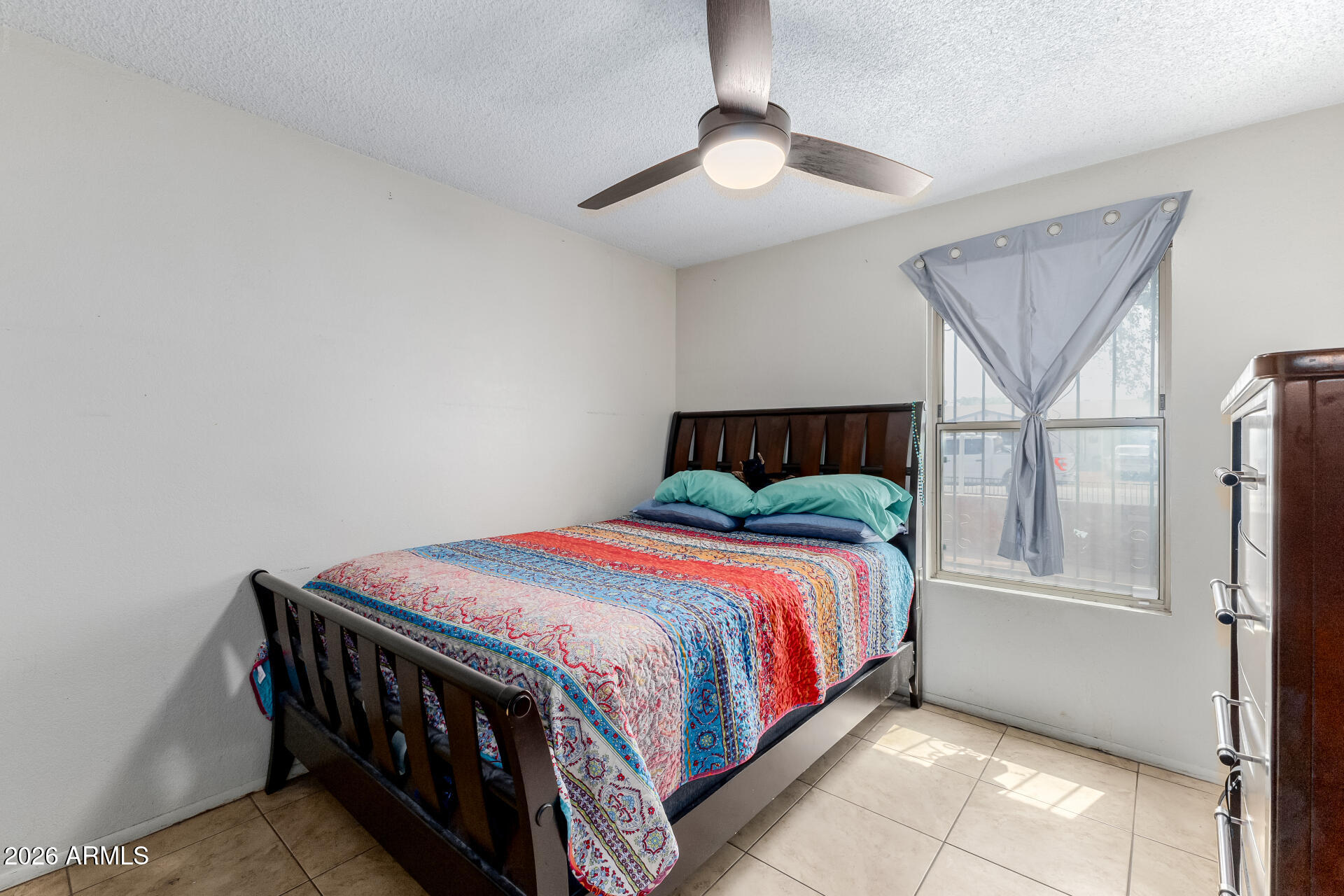 7708 West Flower Street Phoenix, AZ 85033 - Photo 29 of 35 a bedroom with a bed and a chandelier