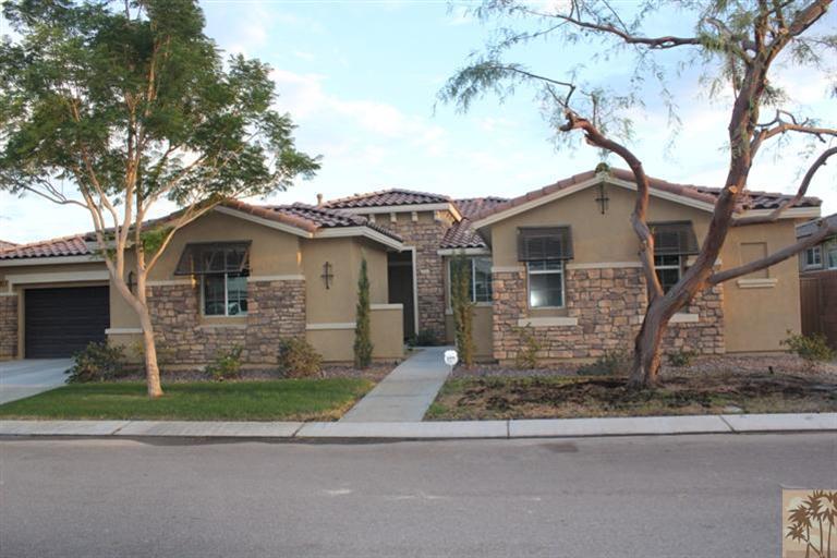 83317 Wagon Road Indio, CA 92203 - Photo 1 of 17 a front view of a house with a garden and trees