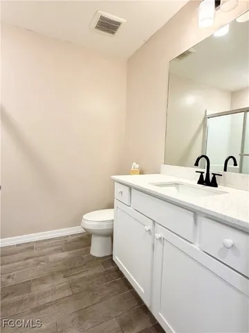 a bathroom with a toilet a sink and mirror