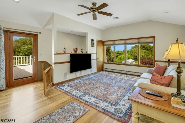 a bedroom with a bed a dresser and potted plant