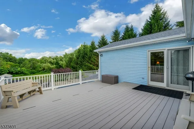 a dining room with wooden floor a chandelier a wooden table and chairs