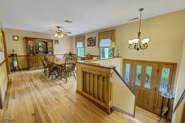 a view of a dining room with furniture a chandelier and wooden floor