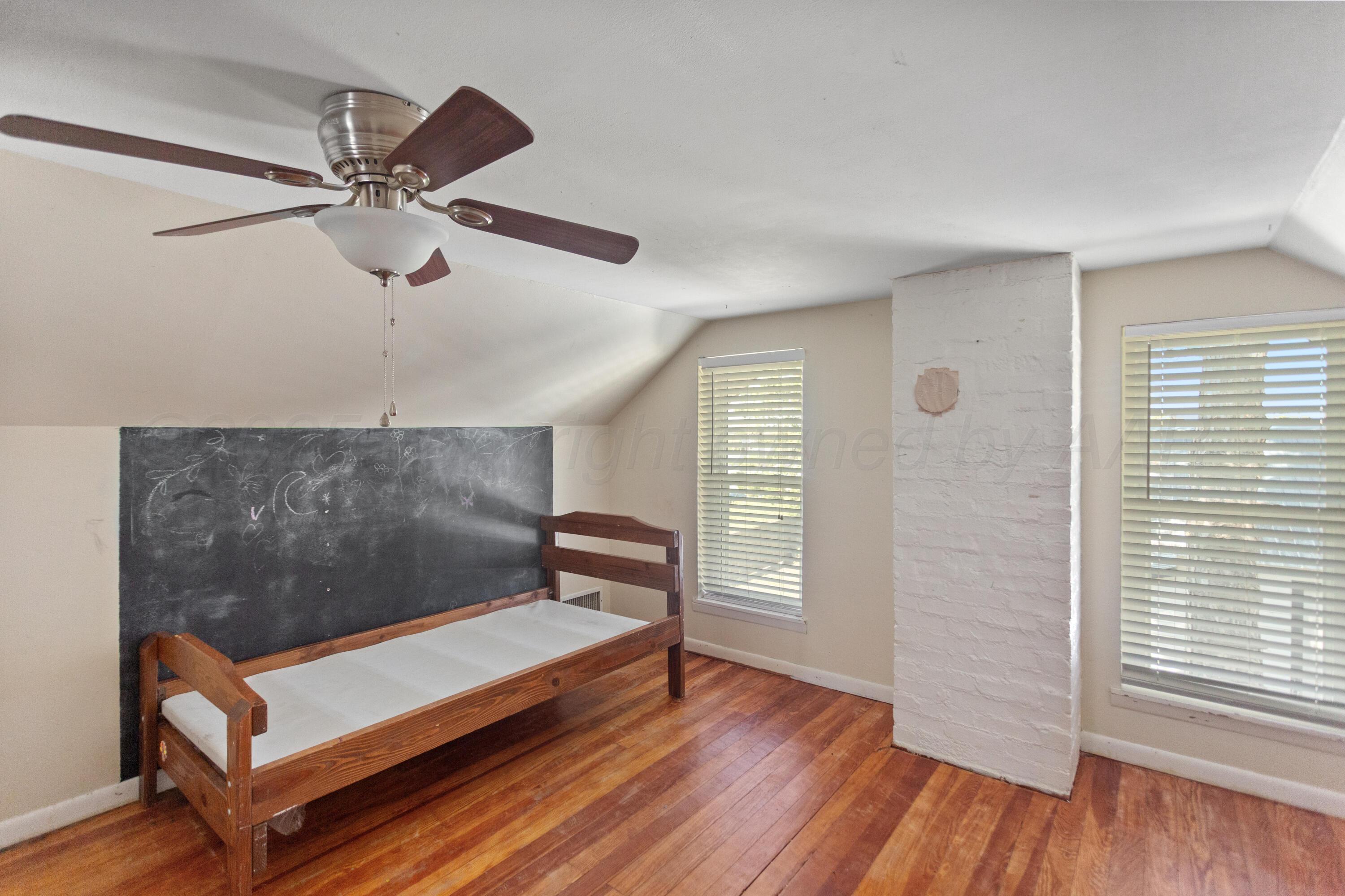 220 West Wichita Street Miami, TX 79059 - Photo 14 of 22 a bedroom with a bed and wooden floor