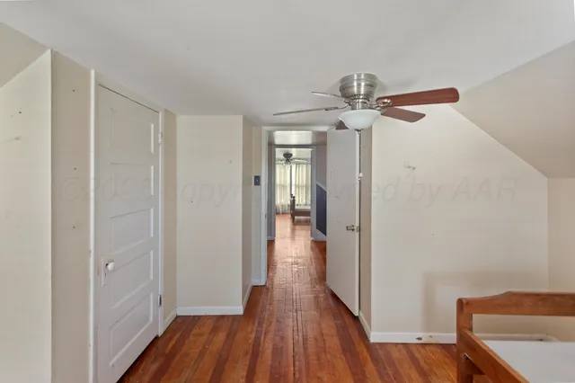 a view of a hallway with wooden floor and chandelier