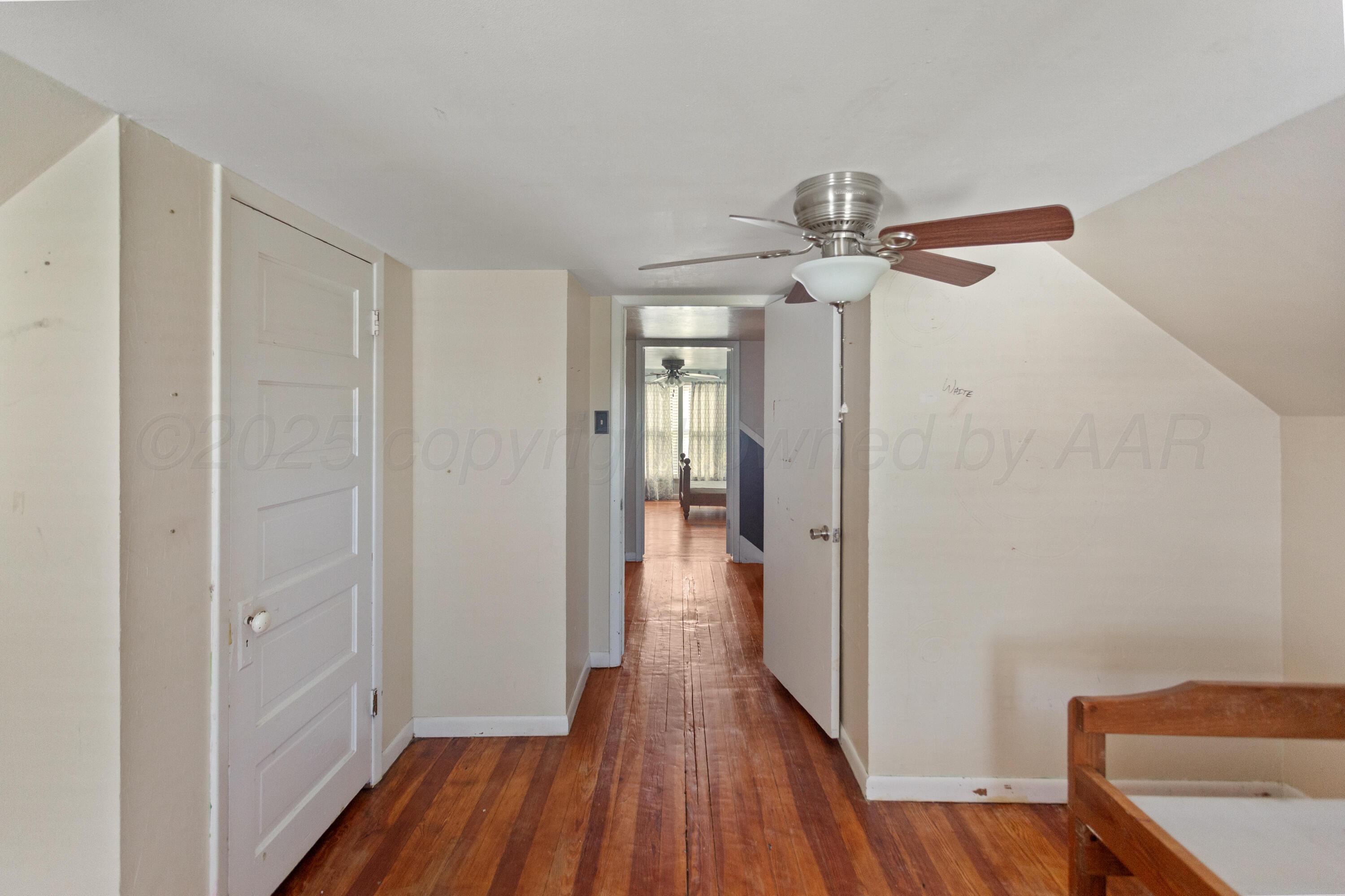 220 West Wichita Street Miami, TX 79059 - Photo 15 of 22 a view of a hallway with wooden floor and chandelier