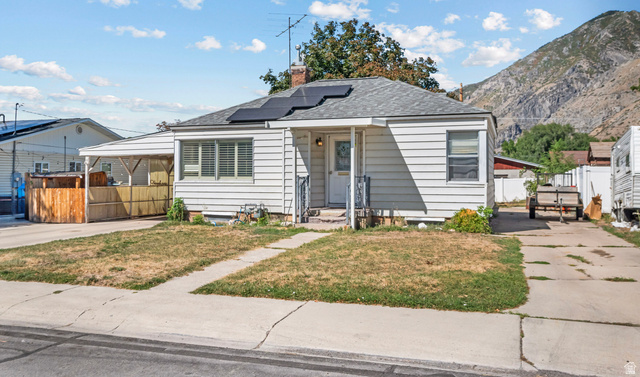 31 B Street Springville, UT 84663 - Photo 2 of 31 Single-story residence featuring white siding, a covered porch entry, and an asphalt shingle roof with visible solar panels