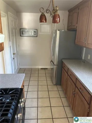 a view of a refrigerator in kitchen and utility room