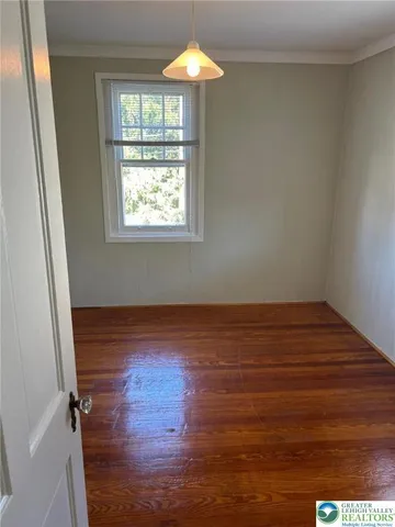 a view of a room with wooden floor fan and a window
