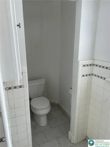 a white toilet sitting next to a shower