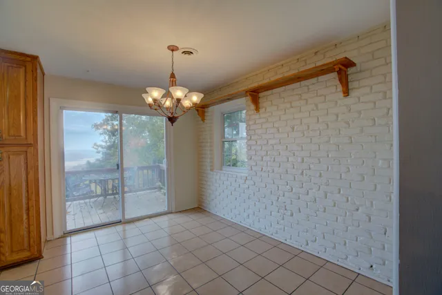 a view of a hallway with windows and chandelier