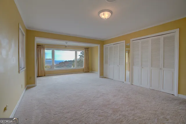 a view of an empty room with glass door and a window