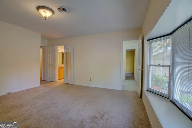 an empty room with closet and windows