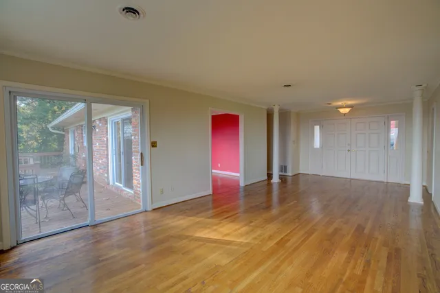 a view of empty room with wooden floor