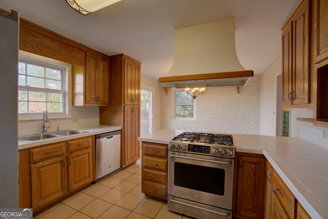 a kitchen with stainless steel appliances granite countertop a stove and a sink