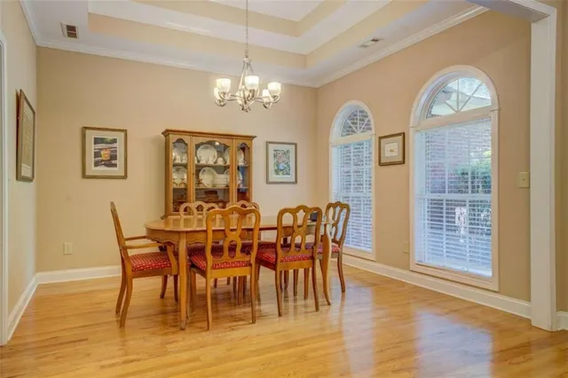 a view of a dining room with furniture a chandelier and wooden floor