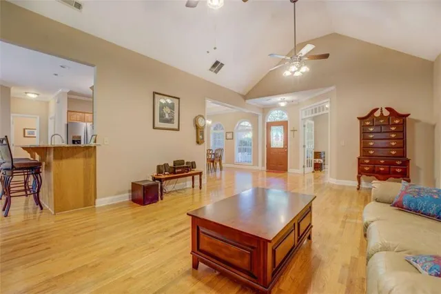 a living room with furniture a table and kitchen view