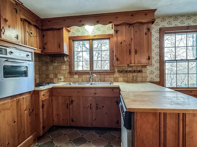 a kitchen with stainless steel appliances granite countertop a sink and a refrigerator