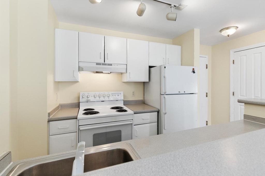 534 Beacon Street, Unit 302 Boston, MA 02215 - Photo 6 of 18 a kitchen with a stove cabinets and refrigerator