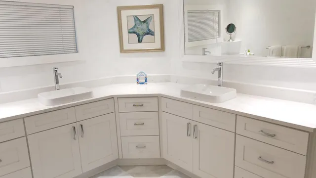 a bathroom with white cabinets sink and mirror