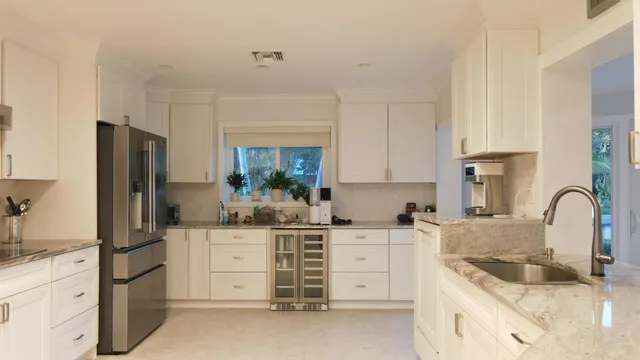 a kitchen with granite countertop a sink stove and refrigerator