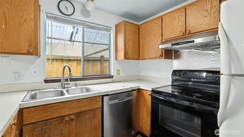 a kitchen with granite countertop cabinets stainless steel appliances and a sink