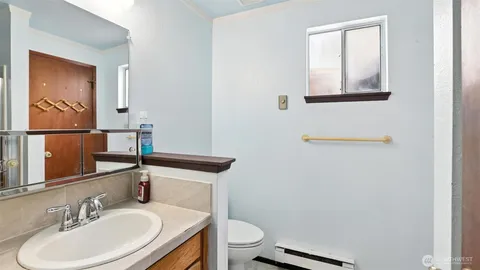 a bathroom with a sink a toilet and mirror