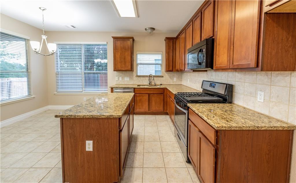 12017 Springs Head Loop Austin, TX 78717 - Photo 7 of 25 A well-lit culinary space features rich cabinetry and sparkling granite countertops.