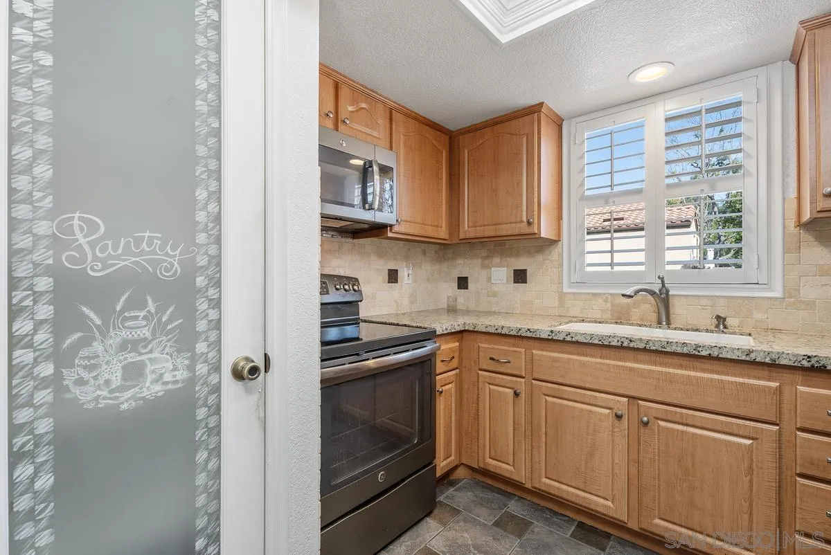 142 North Mine Canyon Road, Unit A Orange, CA 92869 - Photo 8 of 18 a kitchen with stainless steel appliances granite countertop white cabinets sink and window