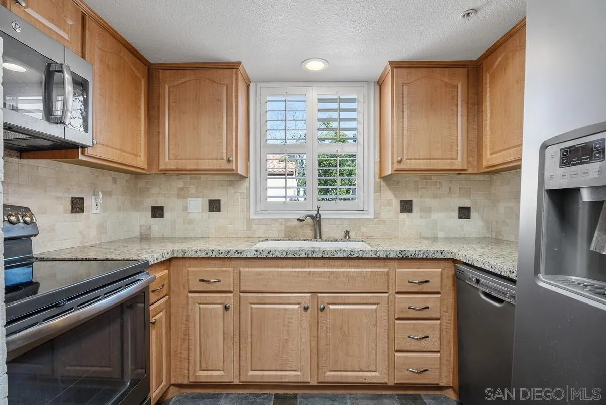 142 North Mine Canyon Road, Unit A Orange, CA 92869 - Photo 9 of 18 a kitchen with granite countertop a sink stove and cabinets
