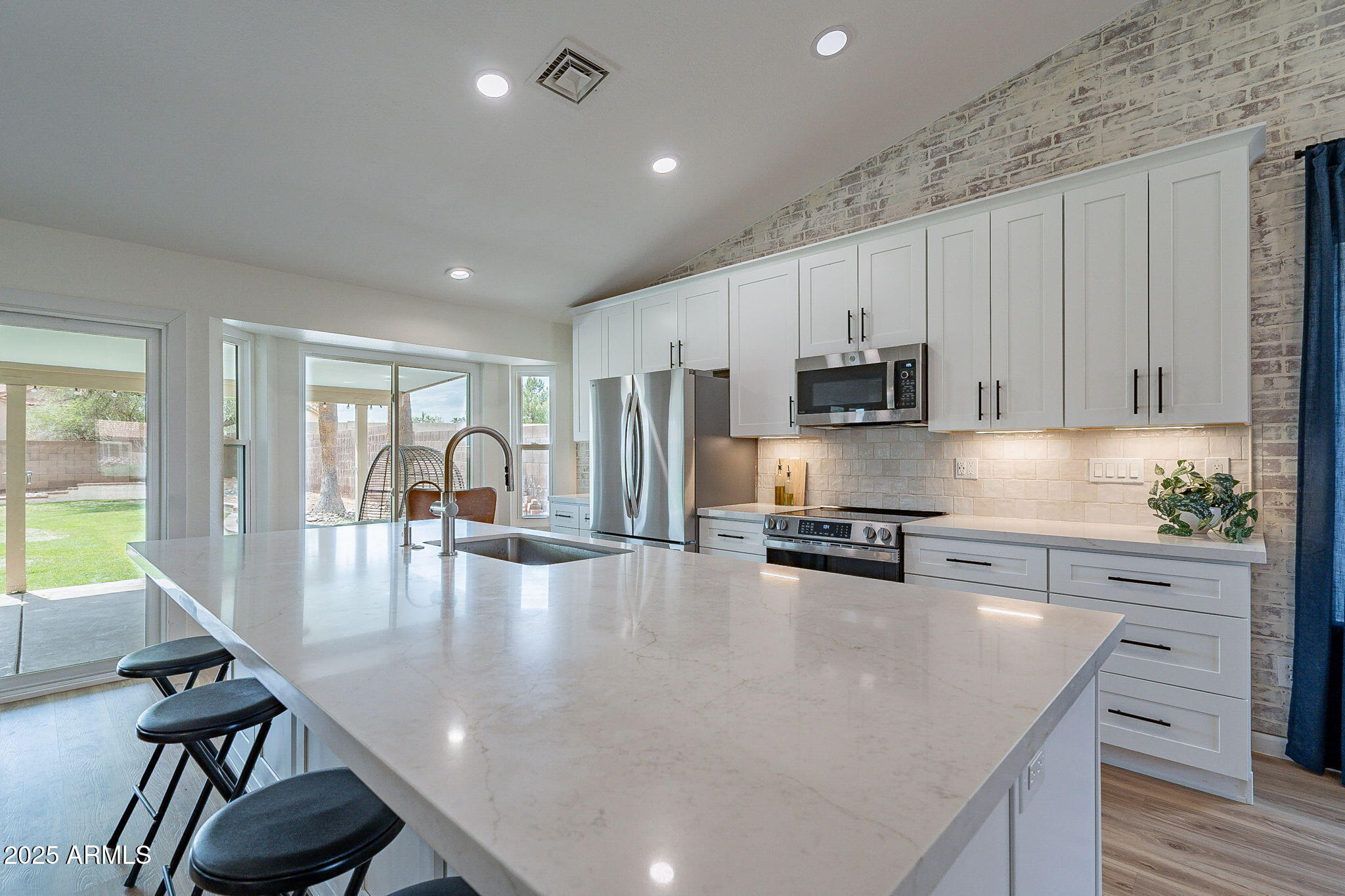 15026 South 28th Street Phoenix, AZ 85048 - Photo 9 of 40 a kitchen with stainless steel appliances granite countertop a stove a refrigerator a sink a stove and white cabinets with wooden floor