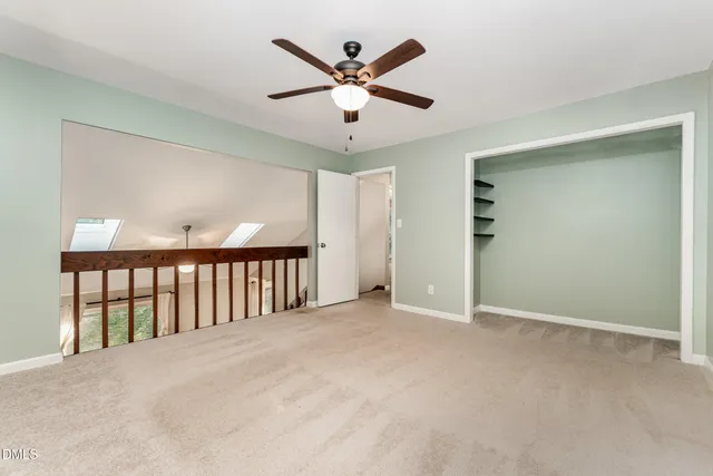 an empty room with ceiling fan and window