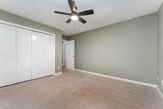 an empty room with a ceiling fan and a window